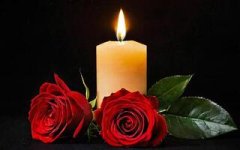 burning-yellow-candle-and-two-red-roses-on-a-black-background-photo.jpg